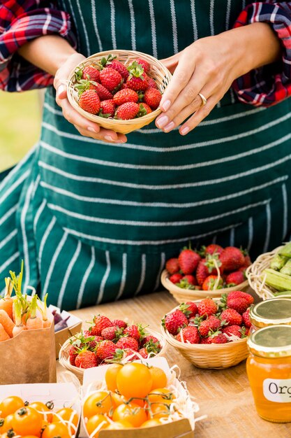 Midsection of woman selling strawberries