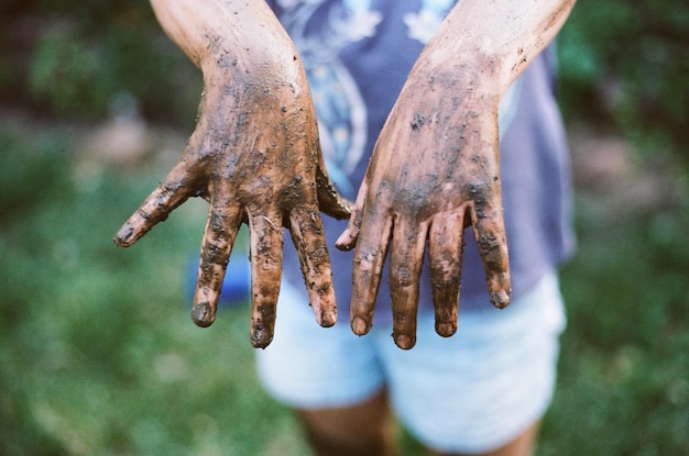 Photo midsection of woman showing muddy hands