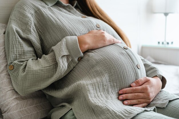 Foto sezione centrale di una donna seduta sul letto a casa