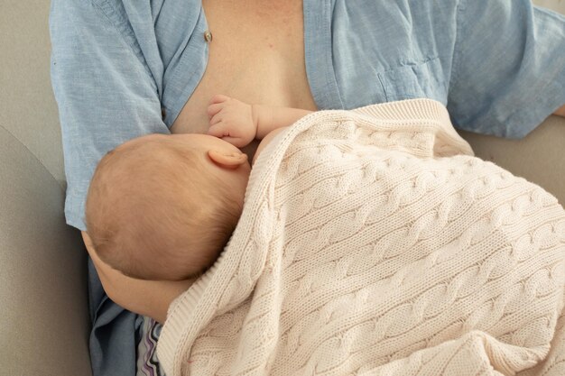 Midsection of woman sitting on bed at home