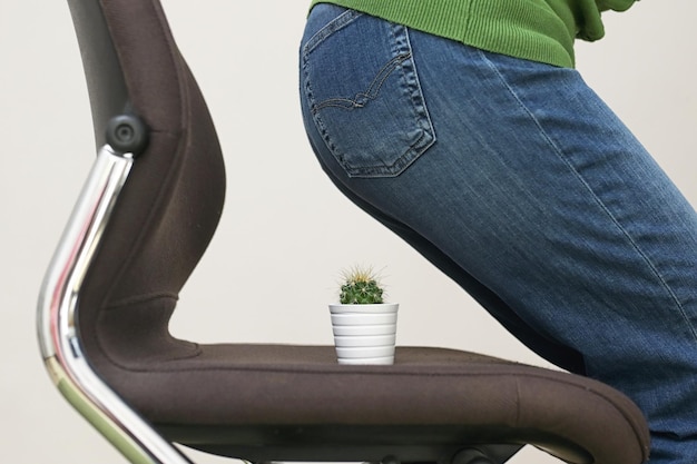 Midsection of woman sitting on potted plant