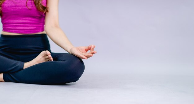 Midsection of woman sitting on table against clear sky