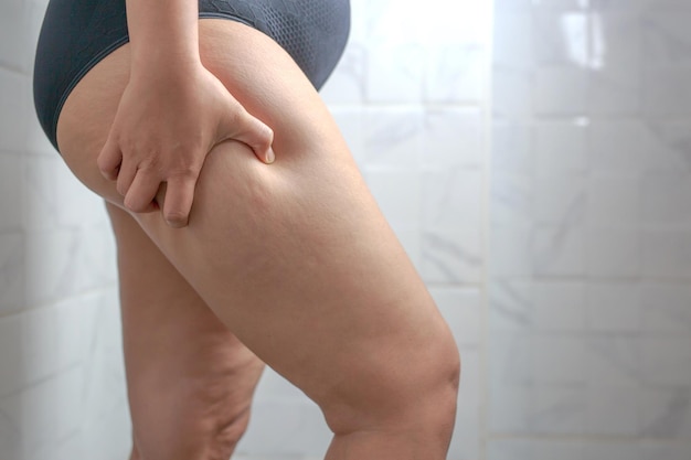 Midsection of woman sitting on wall at home