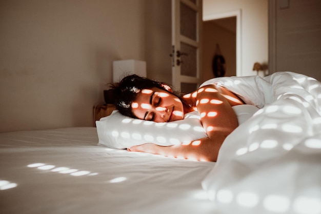 Midsection of woman sleeping on bed