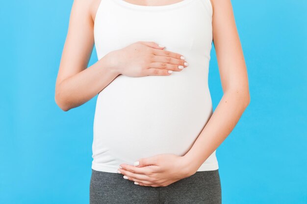 Midsection of woman standing against blue background