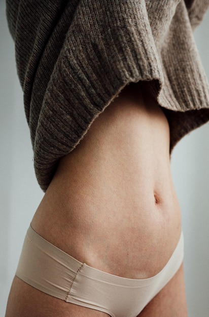 midsection of woman standing against gray background
