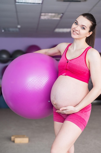 Midsection of woman standing against pink wall