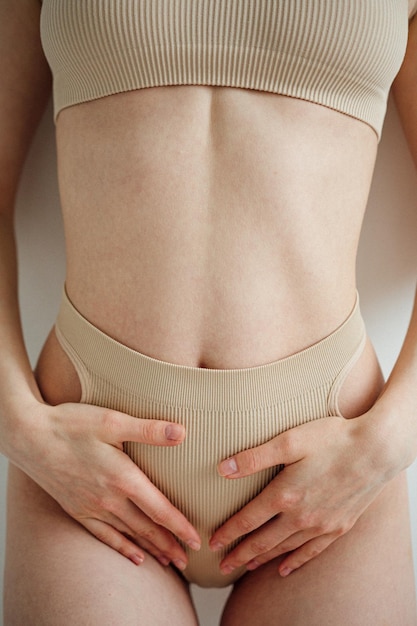 midsection of woman standing against wall