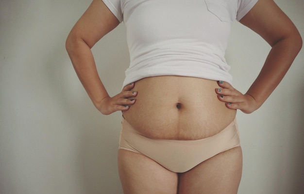 Midsection of woman standing against white background