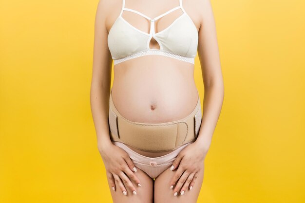 Midsection of woman standing against yellow background