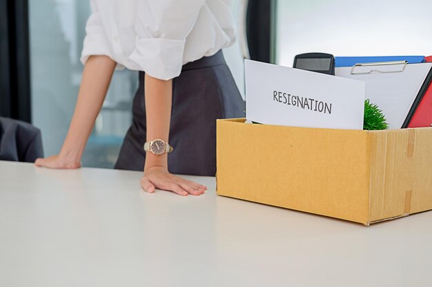 Photo midsection of woman standing by box with text on table