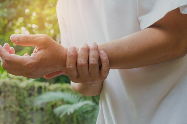 Foto sezione media di una donna che soffre di dolore al polso all'aperto