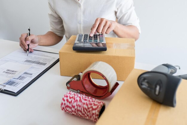 Photo midsection of woman using calculator while sitting on table