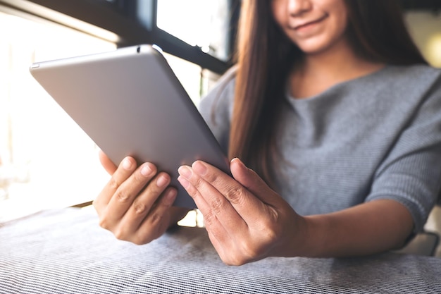 Photo midsection of woman using digital tablet at cafe