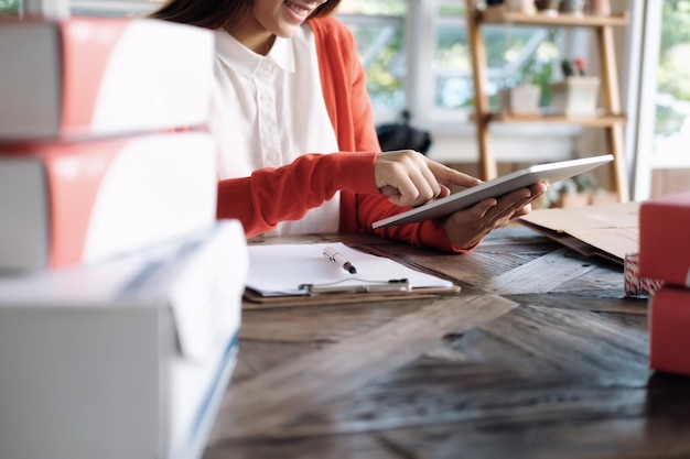 Midsection of woman using digital tablet at office