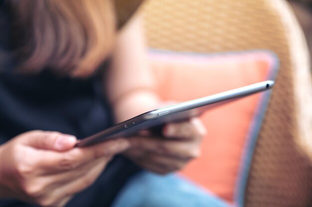 Photo midsection of woman using digital tablet while sitting on chair