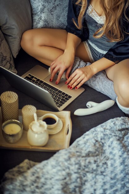 Photo midsection of woman using laptop on sofa at home