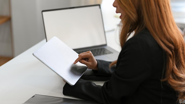 Midsection of woman using laptop on table