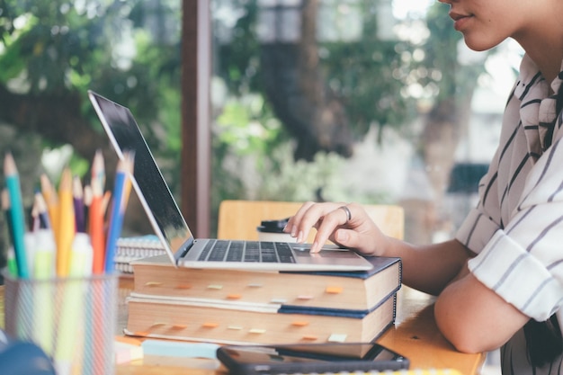 Midsection of woman using laptop on table