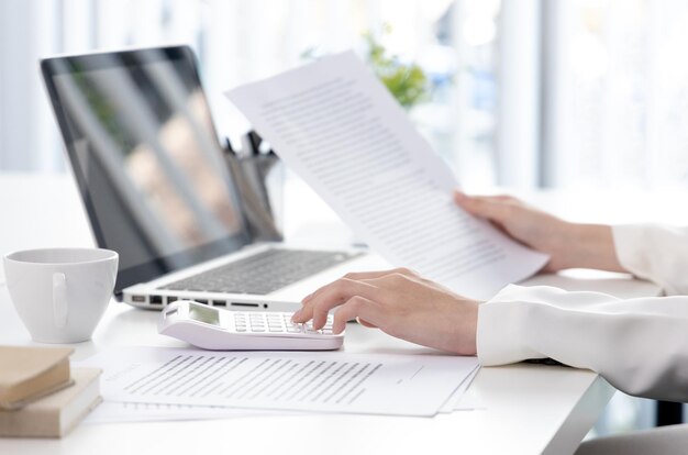 Photo midsection of woman using laptop on table