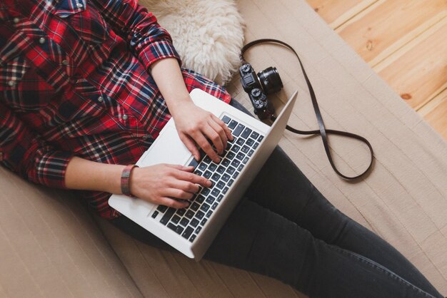 midsection of woman using laptop while resting on sofa at home