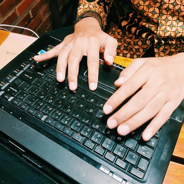 Midsection of woman using laptop