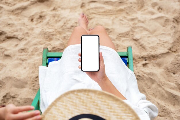 Foto sezione centrale di una donna che usa il telefono cellulare in spiaggia