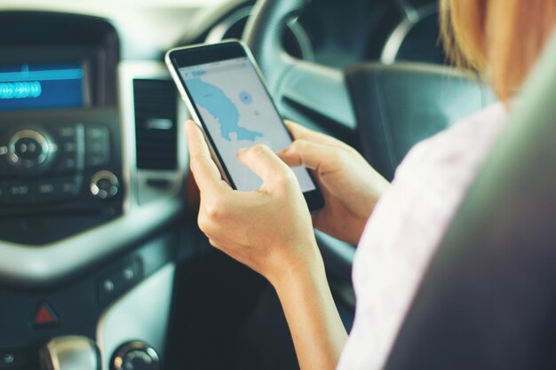 Photo midsection of woman using mobile phone in car