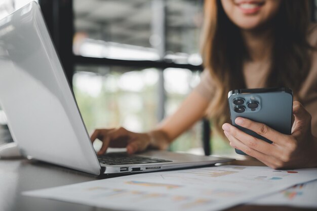 Midsection of woman using mobile phone on table