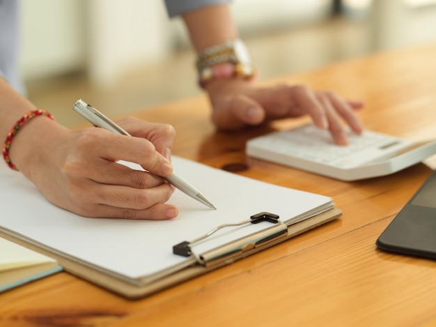 Midsection of woman using mobile phone on table