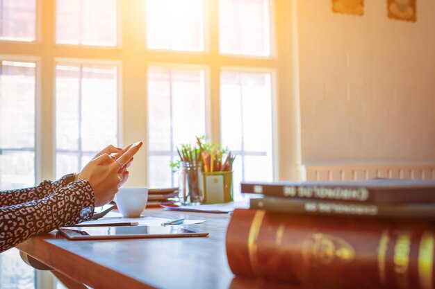 Midsection of woman using mobile phone on table