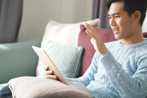 Midsection of woman using mobile phone while sitting on sofa at home