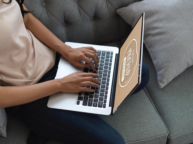 Midsection of woman using mobile phone while sitting on sofa