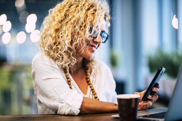 Photo midsection of woman using mobile phone while sitting on table