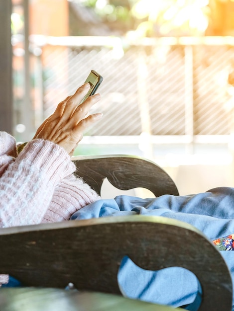 Photo midsection of woman using phone while sitting on chair