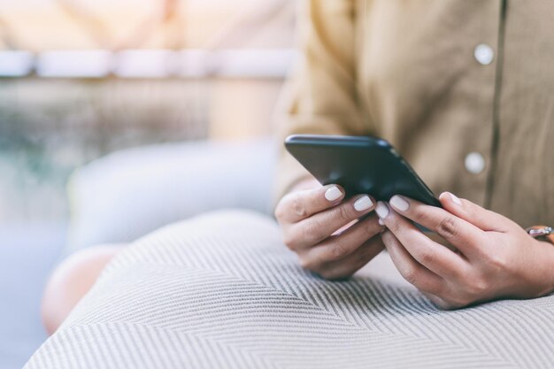 Photo midsection of woman using smart phone in cafe