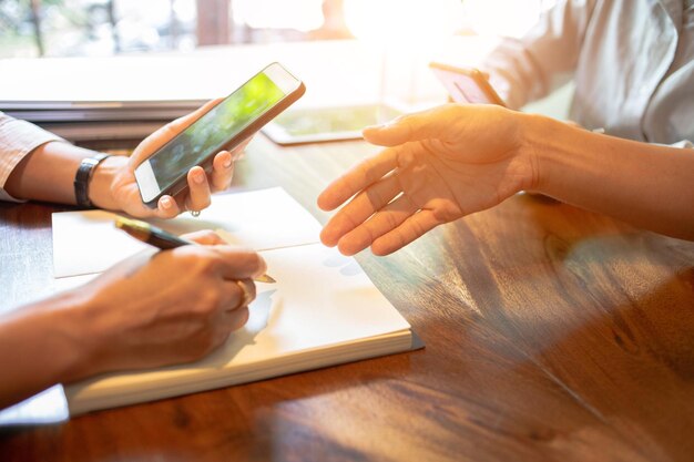 Midsection of woman using smart phone on table