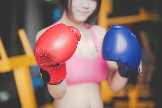 リングに立っている時ボクシングの手袋をかぶった女性のミッドセクション