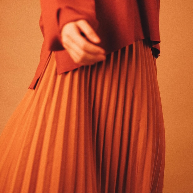 Photo midsection of woman wearing brown clothing by wall