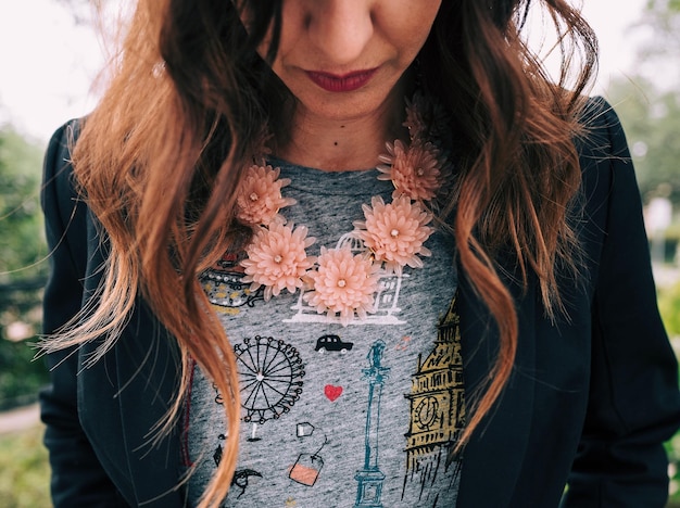 Photo midsection of woman wearing floral patterned necklace outdoors