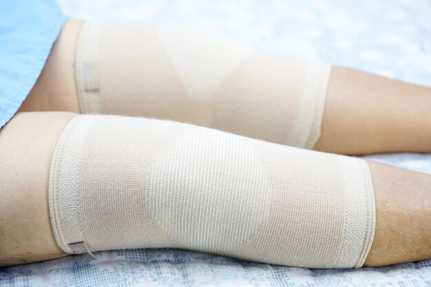 Sezione centrale di una donna che indossa una protesi al ginocchio mentre giace a letto in ospedale