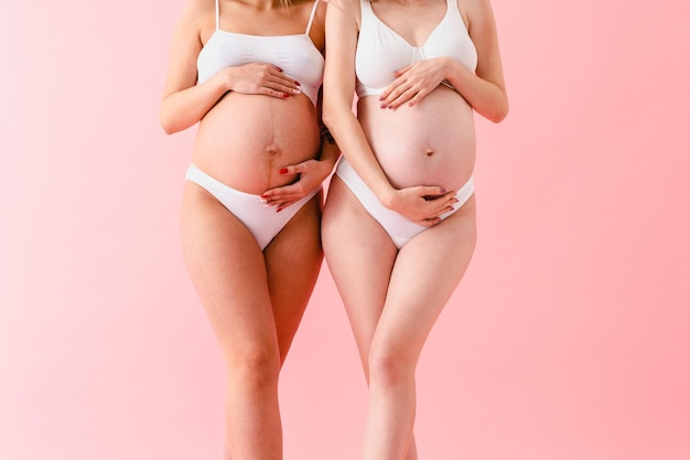 분홍색 배경 에 서 있는 여자 가 속옷 을 입고 있는 중간 부분