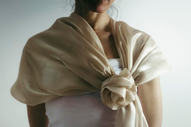 Photo midsection of woman wearing scarf while standing against wall