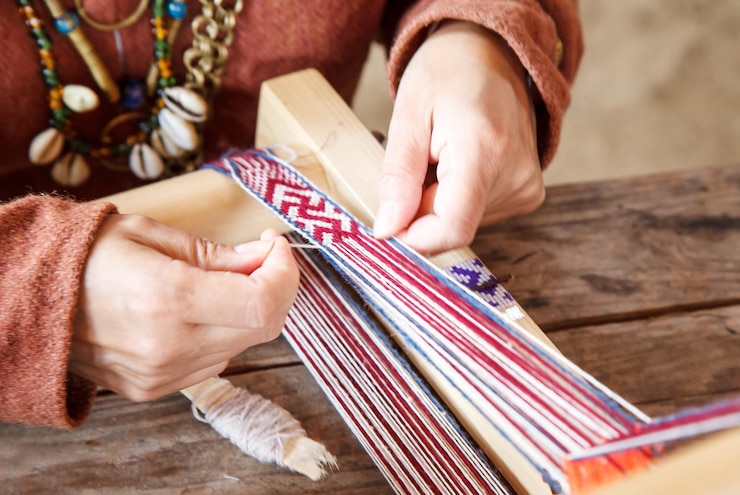 Photo midsection of woman weaving on table at home