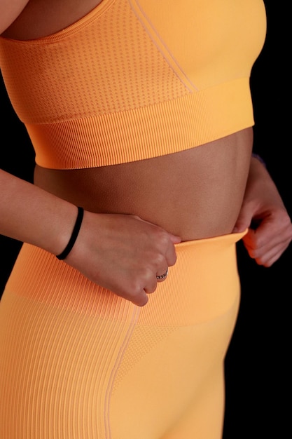 Foto sezione centrale di una donna con le braccia incrociate in abiti da ginnastica
