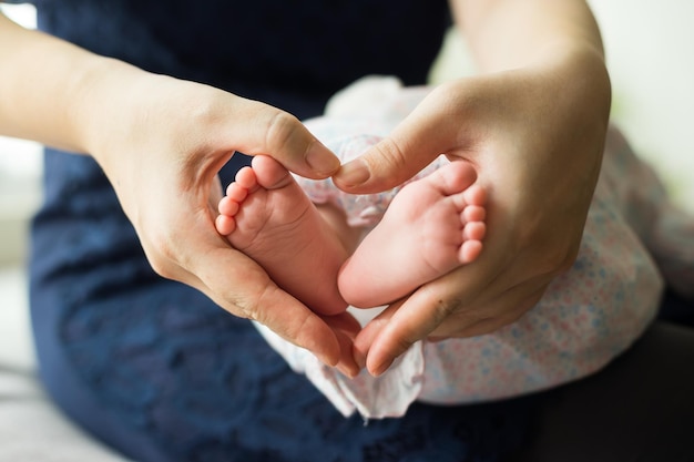 Foto sezione centrale di una donna con un bambino che fa la forma di un cuore con le mani