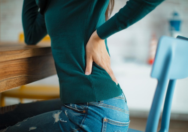 Photo midsection of woman with backache sitting on chair