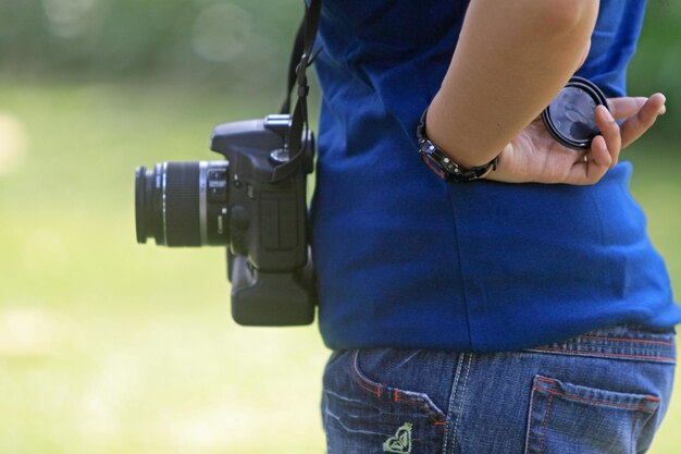 Photo midsection of woman with camera standing outdoors