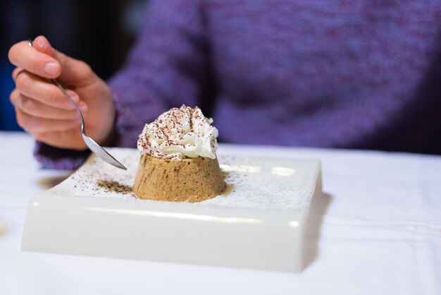 Sezione centrale di una donna con il dessert a tavola