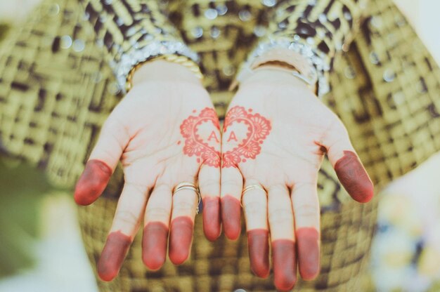 Foto sezione centrale di una donna con un tatuaggio di henna sulle mani